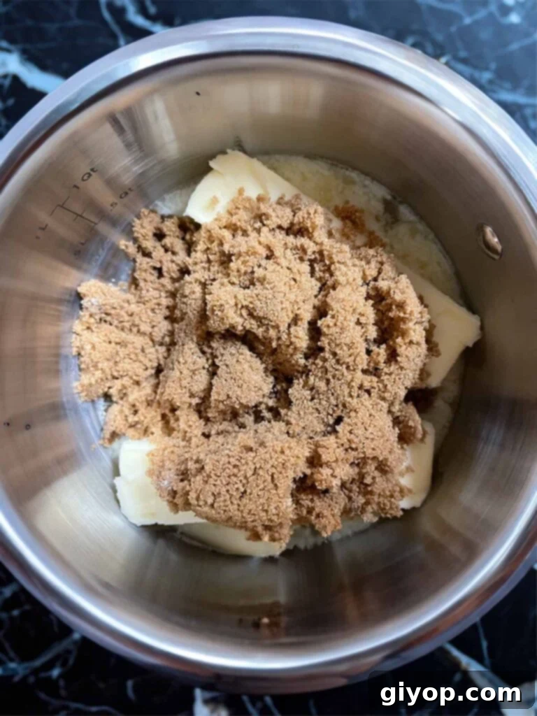 Dark brown sugar and butter heating in a silver saucepan.