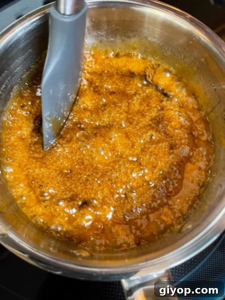 Butter and sugar mixture for oyster cracker churro snack mix boiling in a saucepan.