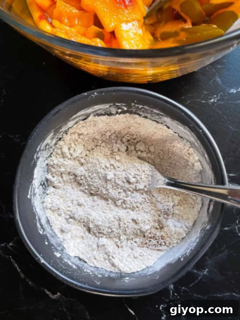 A small ramekin holds a perfectly blended mixture of granulated sugar, brown sugar, cornstarch, and various spices, ready for the peach pie filling.