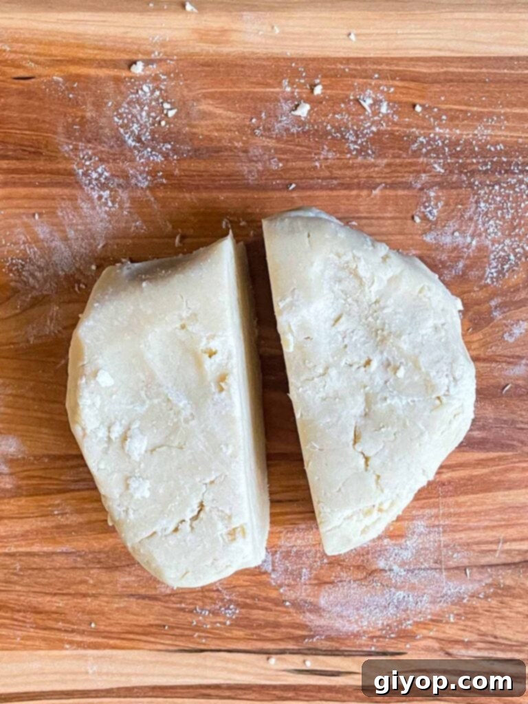 Perfectly Flaky Pie Crust 8 Pie crust dough divided into two disks on a cutting board.