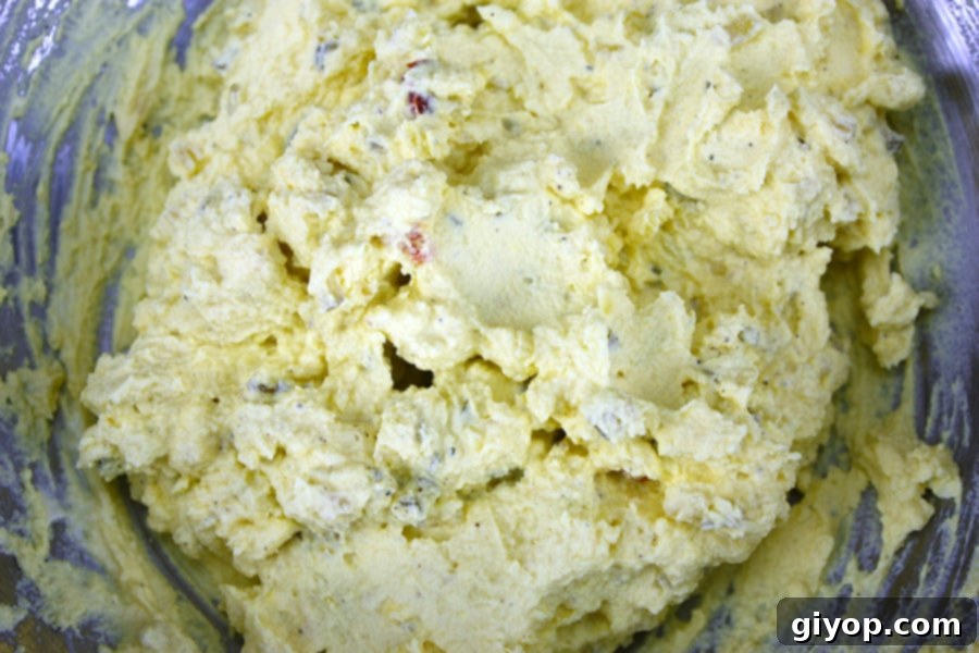 Yolk mixture in a metal bowl, creamy and ready to be piped into egg whites.