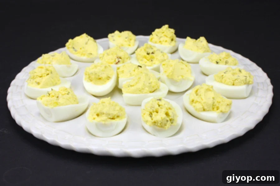Classic Deviled Eggs arranged beautifully on a white deviled egg plate, garnished with paprika.