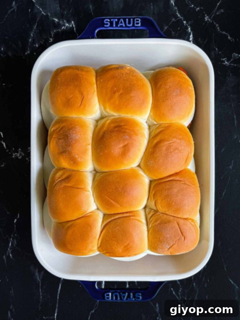 Cheesy Baked Chicken Parmesan Sliders 11 Assembled chicken parmesan sliders, with top buns placed, in a 9x13 inch baking dish.