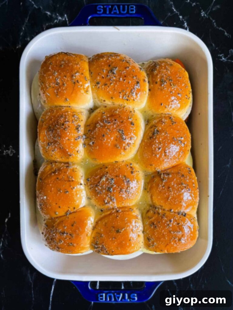 Cheesy Baked Chicken Parmesan Sliders 14 The chicken parmesan sliders in a 9x13 inch pan, meticulously brushed with the butter herb mixture and ready for baking.