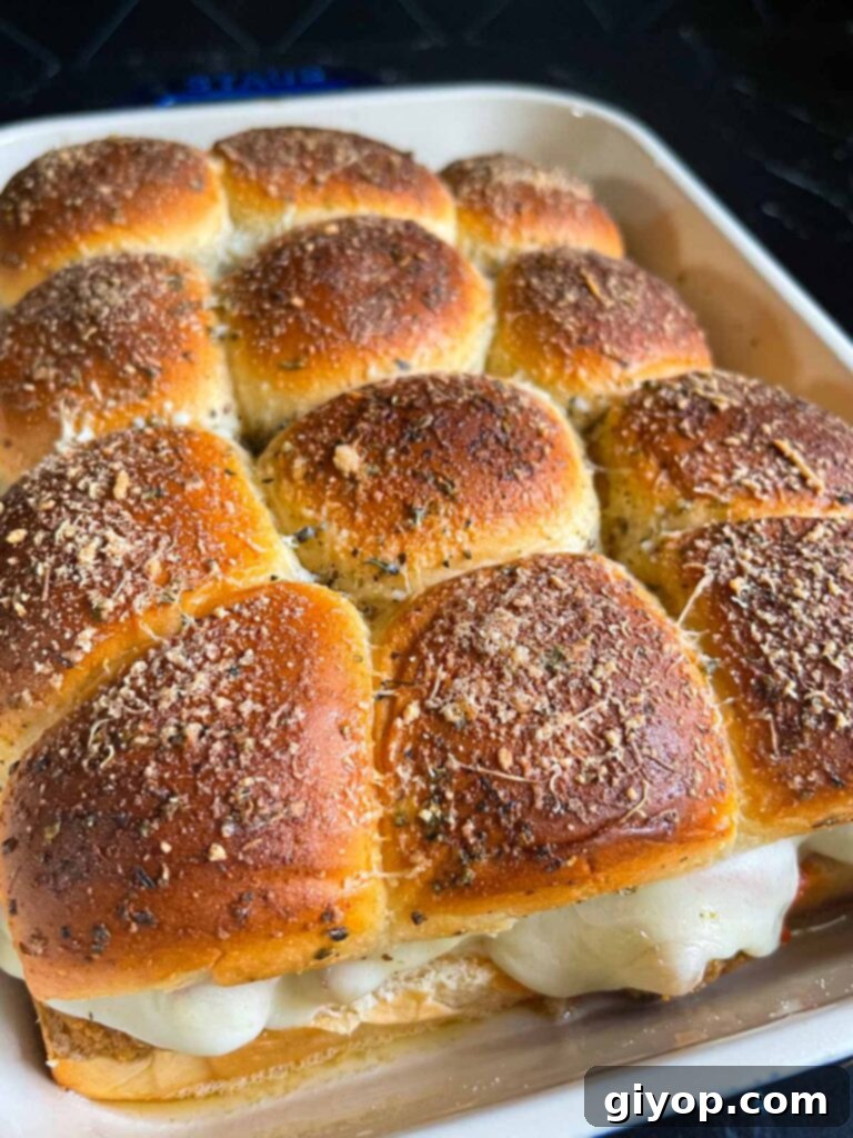 Cheesy Baked Chicken Parmesan Sliders 16 A batch of freshly baked chicken parmesan sliders, golden brown and cheesy, just removed from the oven.