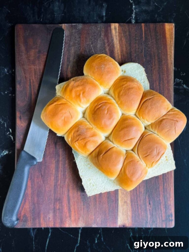 Cheesy Baked Chicken Parmesan Sliders 6 Slider rolls carefully sliced in half on a dark cutting board.