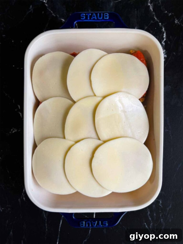 Cheesy Baked Chicken Parmesan Sliders 10 A generous layer of provolone cheese covering the marinara sauce on the chicken parmesan sliders.