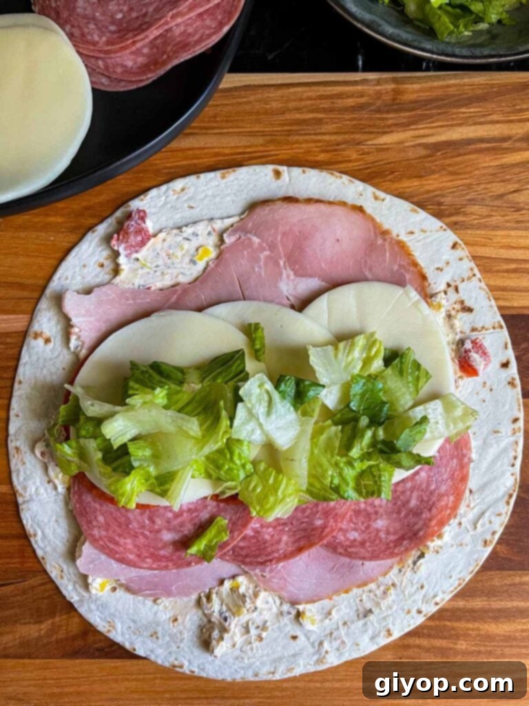 A layer of lettuce on the italian pinwheel as it's being made.