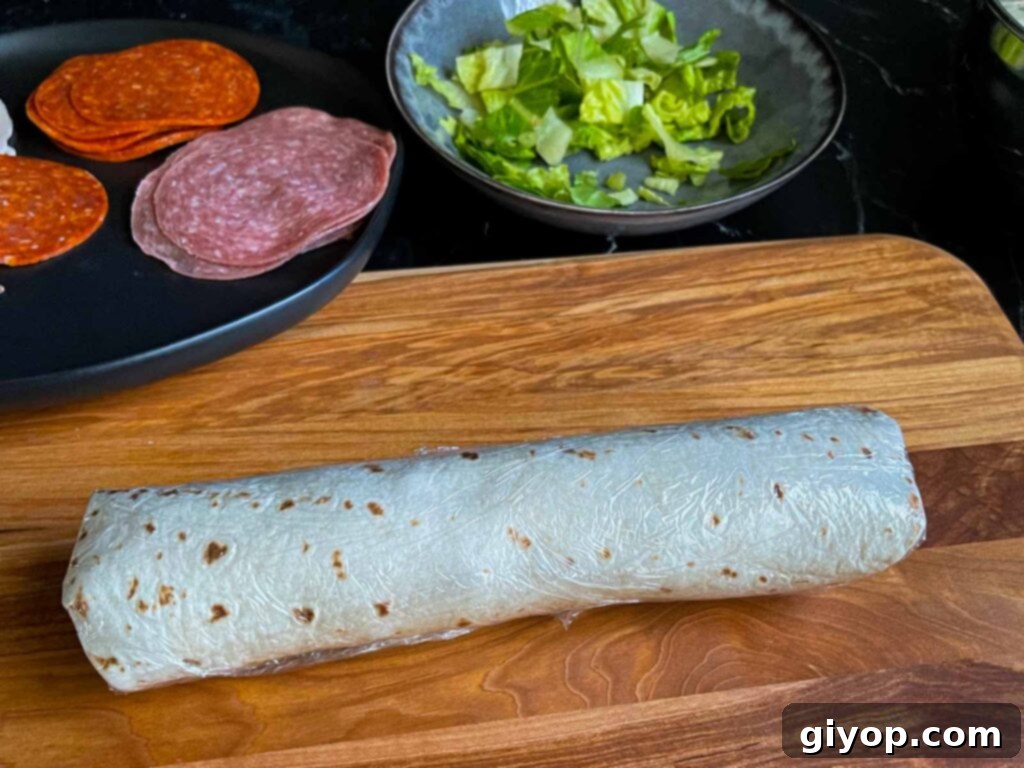 An Italian pinwheel, wrapped up in plastic wrap, unsliced.