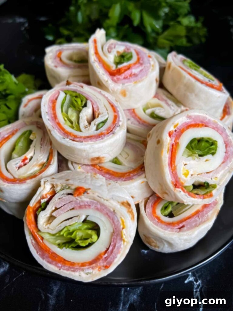 Italian pinwheels on a dark plate on a dark surface.