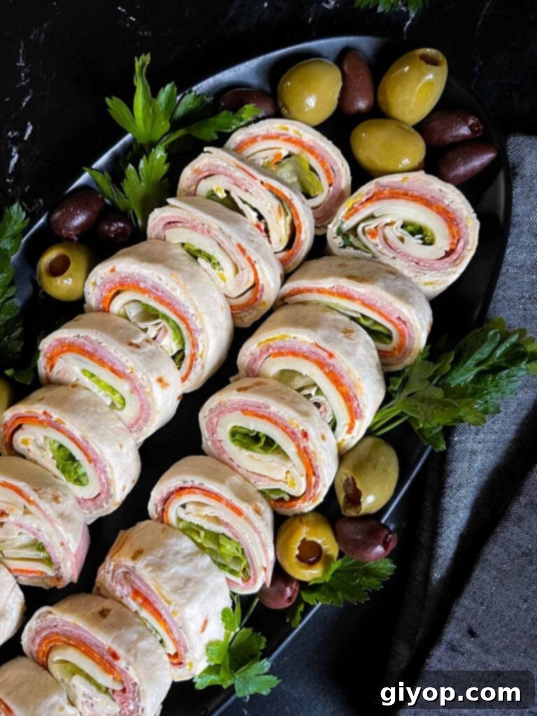 Italian pinwheels on a dark plate on a dark surface.