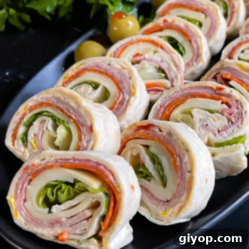 Italian pinwheels on a dark plate on a dark surface.