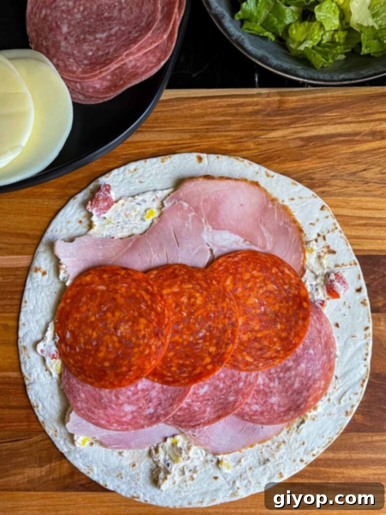 A layer of pepperoni on the italian pinwheel as it's being made.