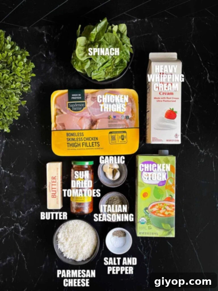 All the key ingredients for Slow Cooker Tuscan Chicken laid out on a dark kitchen surface, including chicken thighs, spinach, sun-dried tomatoes, garlic, and cheese.