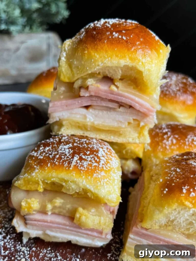 Monte Cristo sliders stacked up on a dark cutting board.