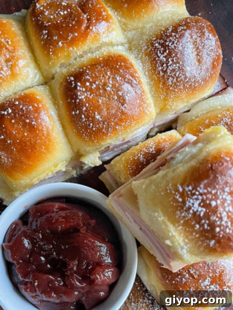 Monte Cristo sliders stacked up on a dark cutting board.