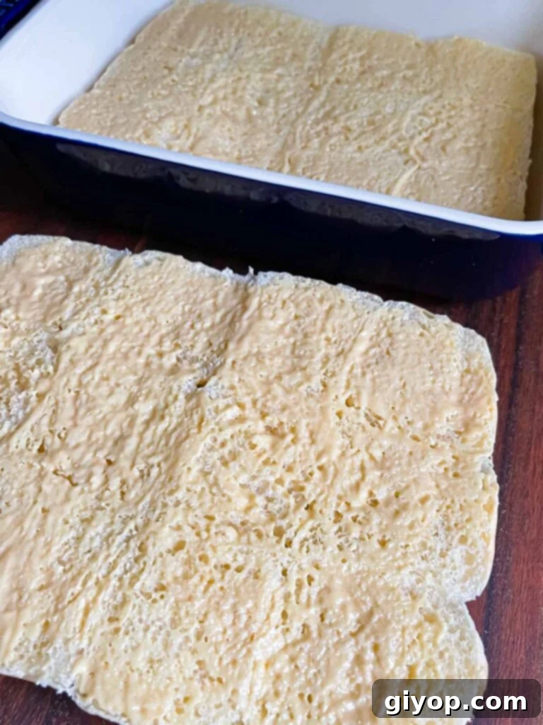 Mustard sauce spread across slider rolls.