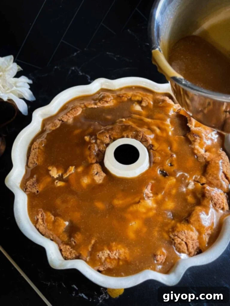 Caramel glaze poured over the apple dapple cake still in a bundt pan.