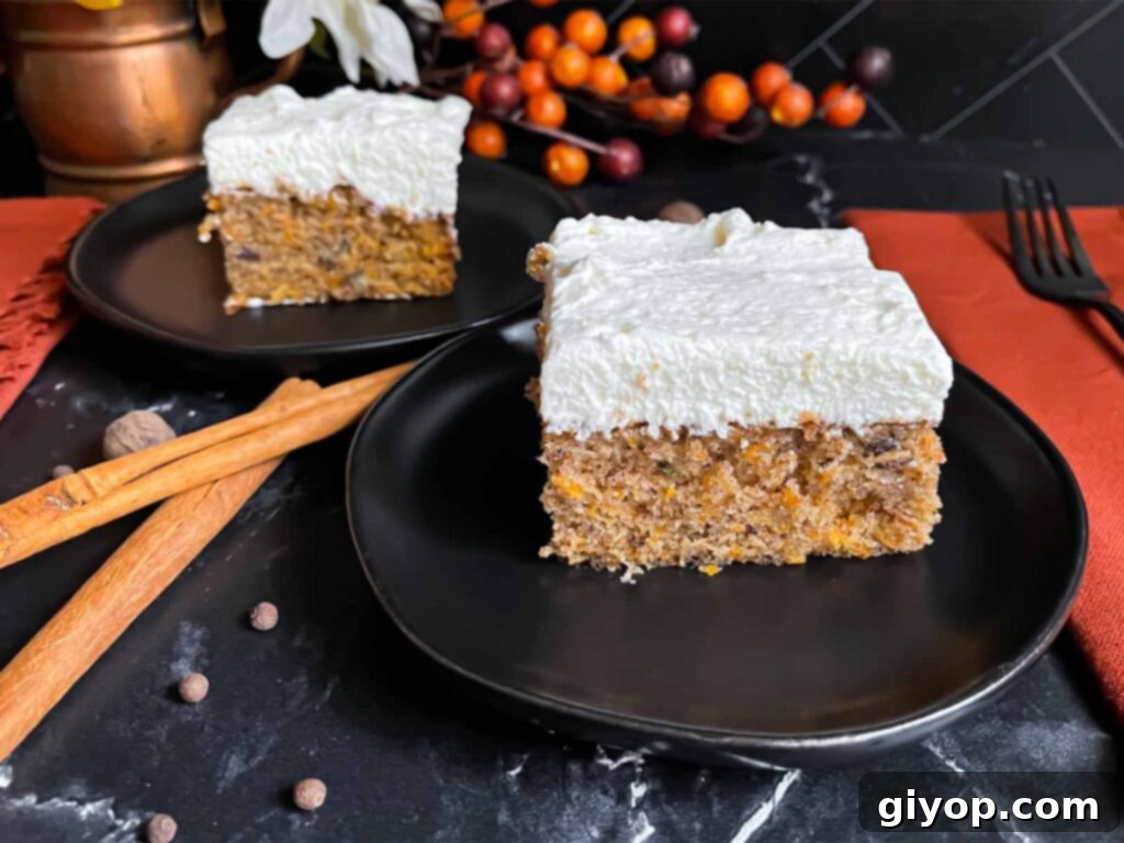 Two slices of moist sweet potato cake topped with creamy white frosting, elegantly presented on dark plates against a dark surface.