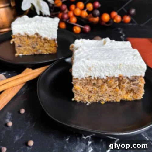 Two slices of sweet potato cake on dark plates on a dark surface.