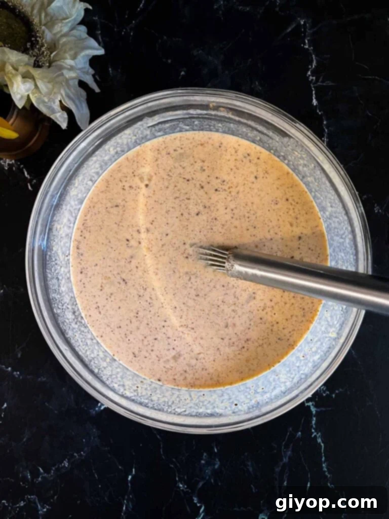 Decadent Pumpkin Bread Pudding with Salted Caramel Drizzle 6 Custard ingredients mixed in a glass bowl for pumpkin bread pudding.