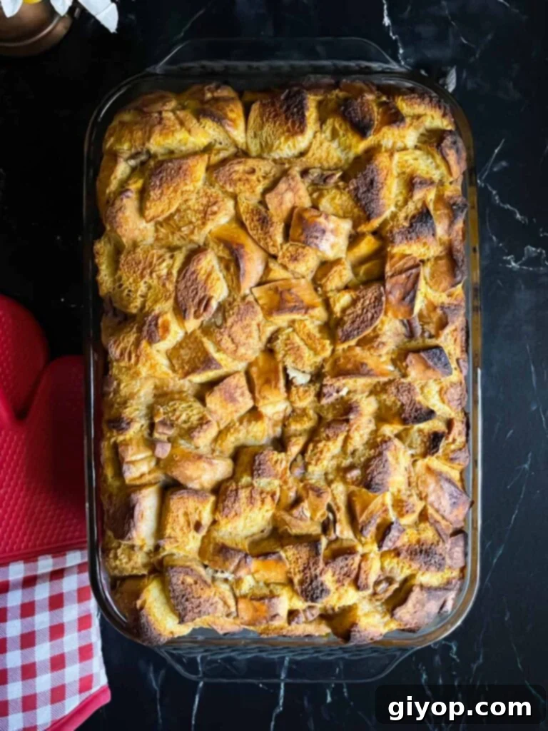 Decadent Pumpkin Bread Pudding with Salted Caramel Drizzle 9 Baked pumpkin bread pudding in a 9x13 baking pan on a dark surface.