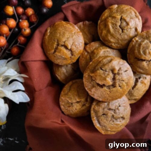 Sweet potato muffins in an orange cloth lined basket with flowers on the side.