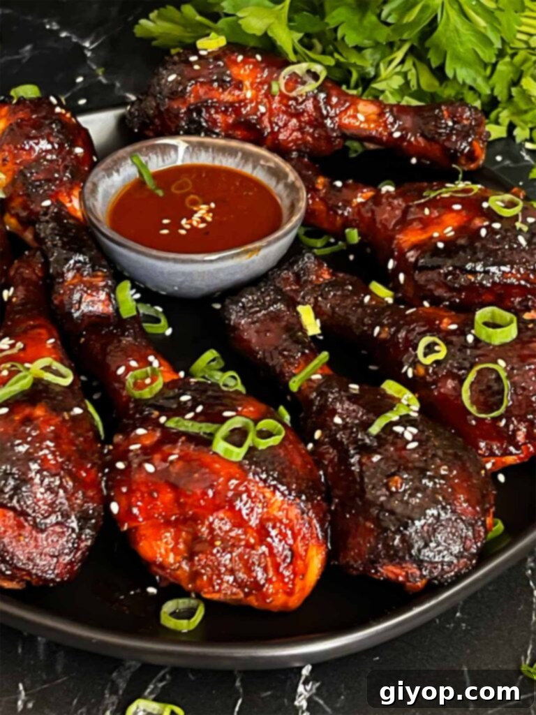 Smoky Gochujang Fire Chicken Legs 11 Smoked gochujang chicken legs on a dark plate.