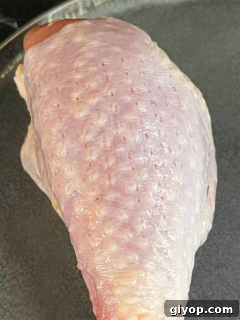 Smoky Gochujang Fire Chicken Legs 5 A chicken leg showing that the skin has been pierced with a meat tenderizer.