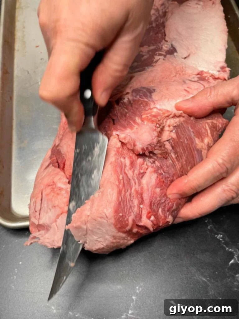 Trimming fat off of a brisket.