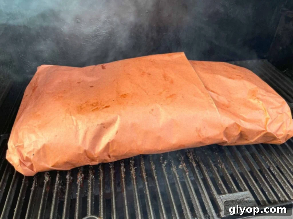 A butcher paper wrapped brisket in a smoker.