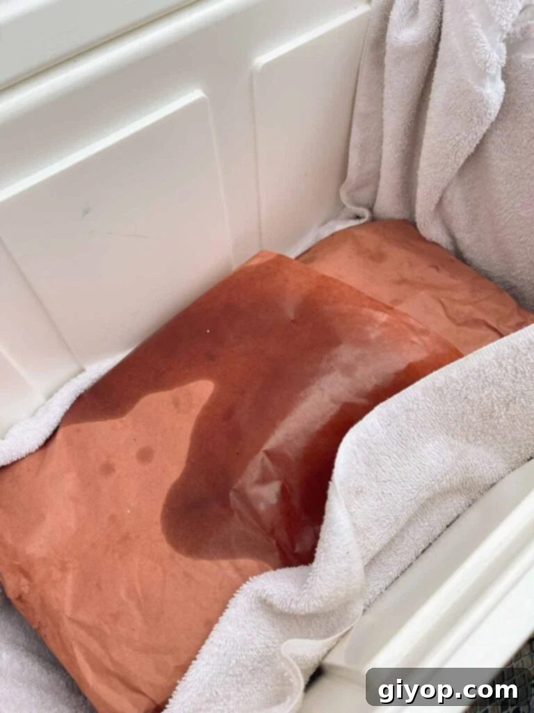 A cooked brisket being stored in a cooler for later consumption.