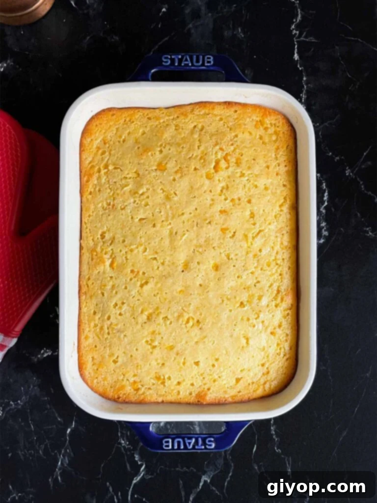 Baked corn casserole on a dark surface.