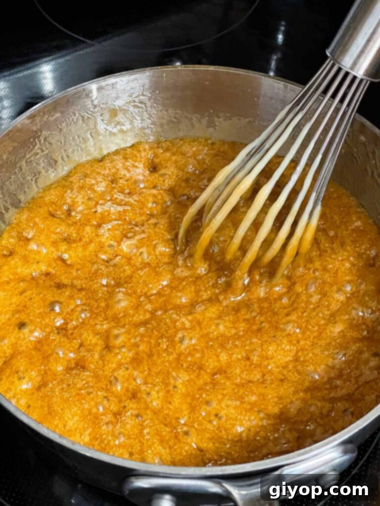 Toffee mixture boiling in a metal saucepan.