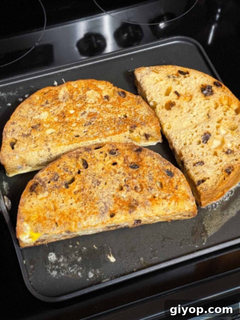 Multiple slices of panettone French toast cooking simultaneously on a large buttered griddle, ensuring even browning.