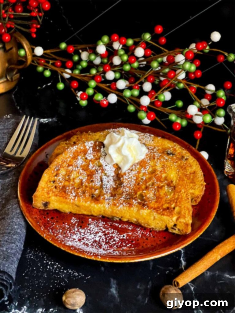 A beautifully plated serving of panettone French toast, garnished with powdered sugar, whipped cream, and a generous pour of maple syrup, ready to be served.