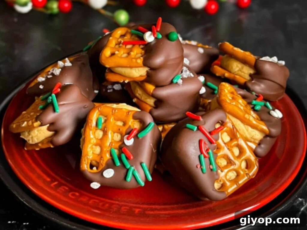 Salty Sweet Peanut Butter Pretzel Treats 2 Chocolate covered peanut butter pretzel bites stacked on a dark plate.