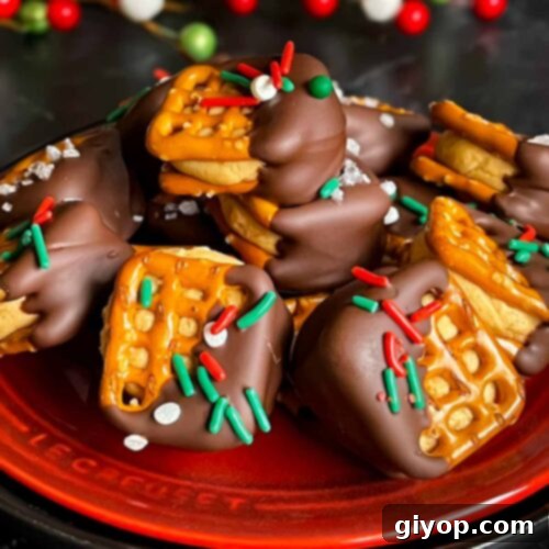 Salty Sweet Peanut Butter Pretzel Treats 9 Chocolate covered peanut butter pretzel bites stacked on a dark plate.