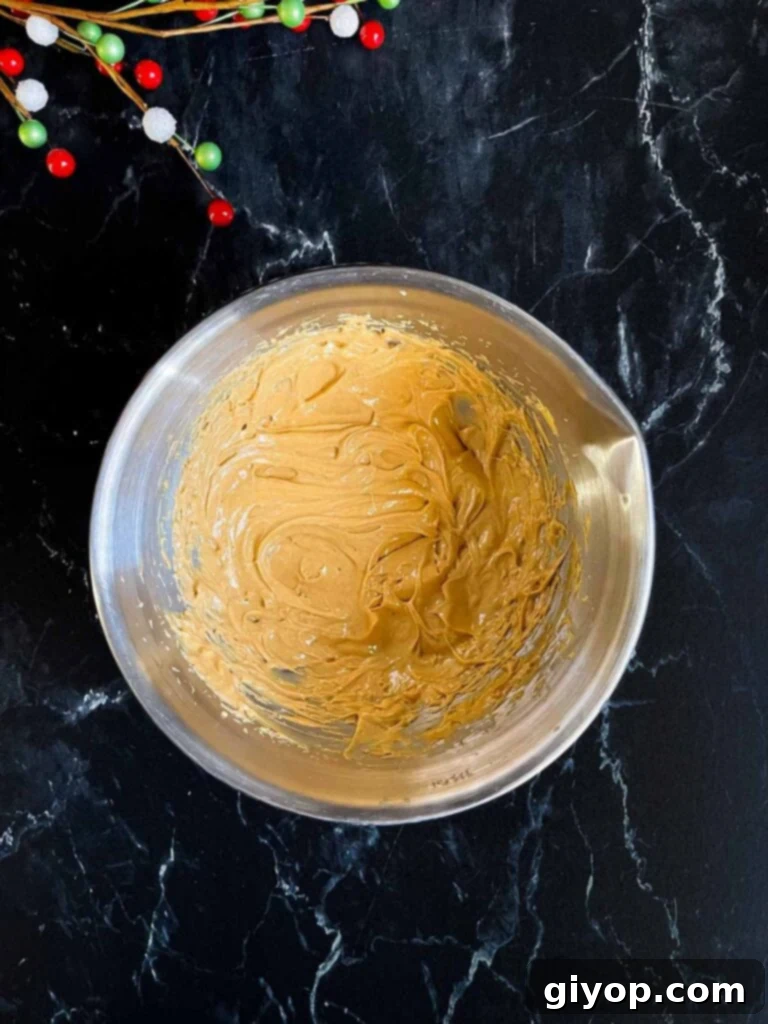 Salty Sweet Peanut Butter Pretzel Treats 4 Peanut butter and softened butter mixed together in a metal mixing bowl.