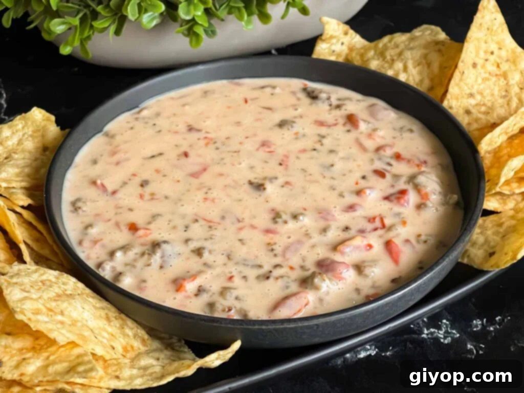 Velveeta cheese dip in a dark bowl with tortilla chips.