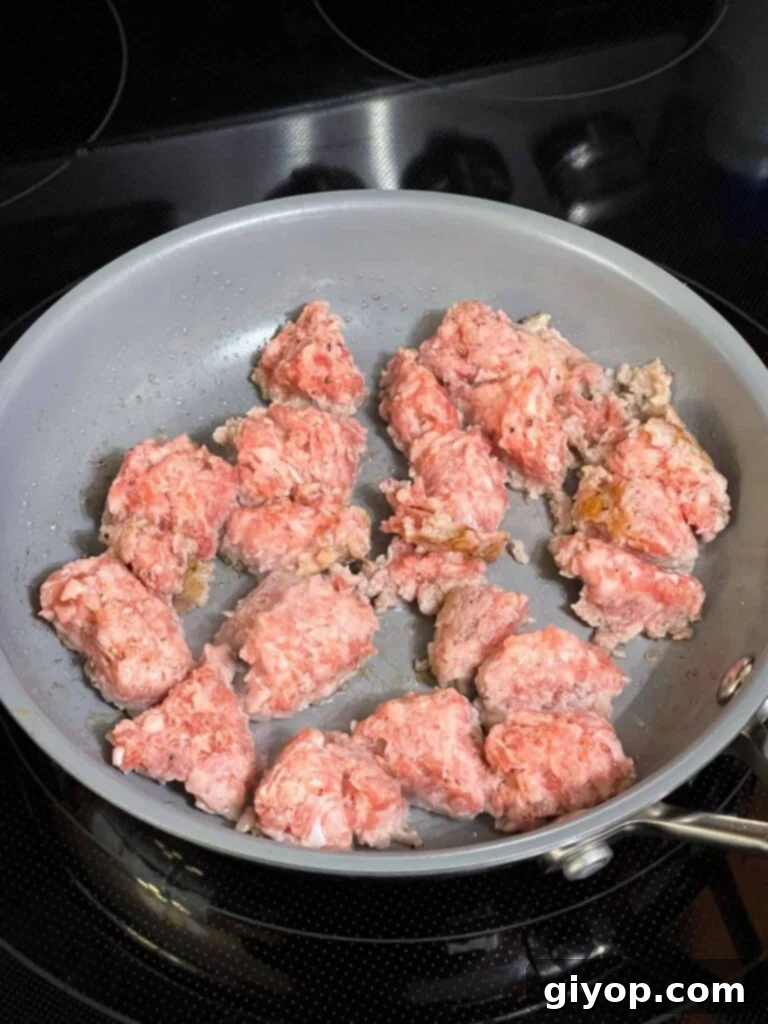 Breakfast sausage cooking in a small skillet.
