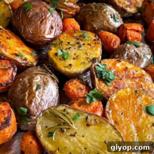 Roasted potatoes and carrots on a baking sheet.