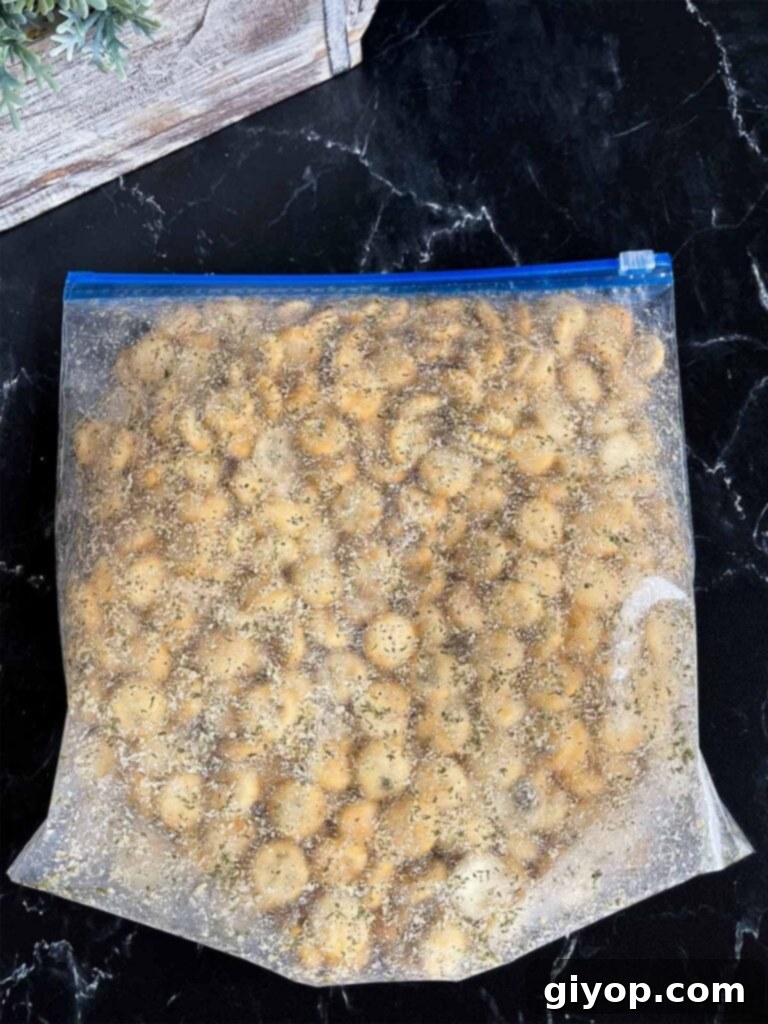 Savory Dill Oyster Crackers 6 Dill oyster crackers sealed in a plastic bag on a dark surface, showing the coating process.