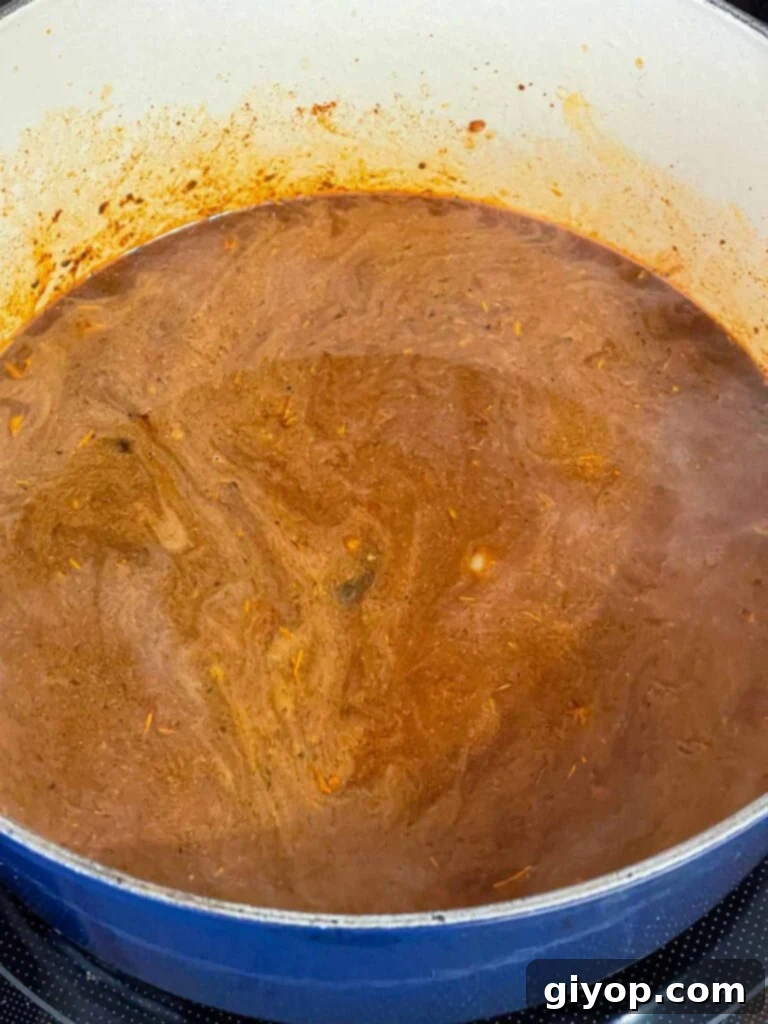 A brisket chili base cooking in a dutch oven.