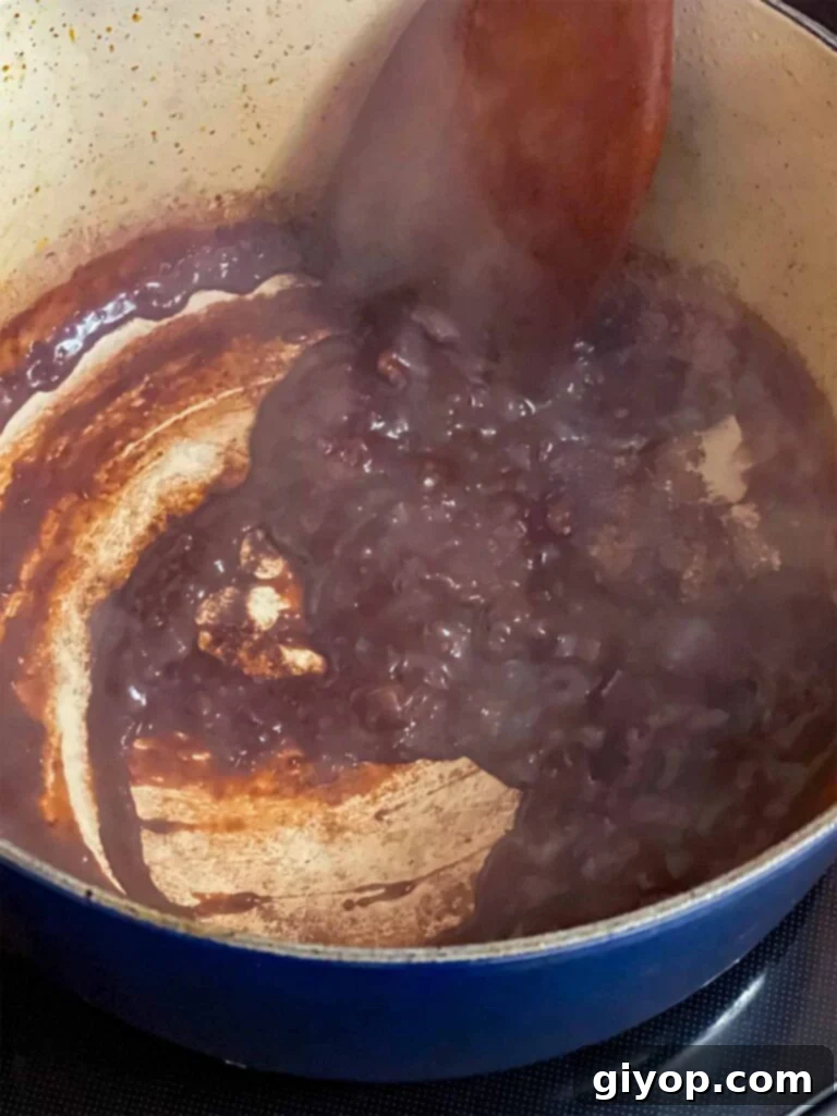 Red wine reducing in the dutch oven with the other ingredients for the pot roast recipe.