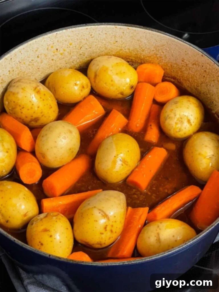 Potatoes and carrots added to the dutch oven with the pot roast.