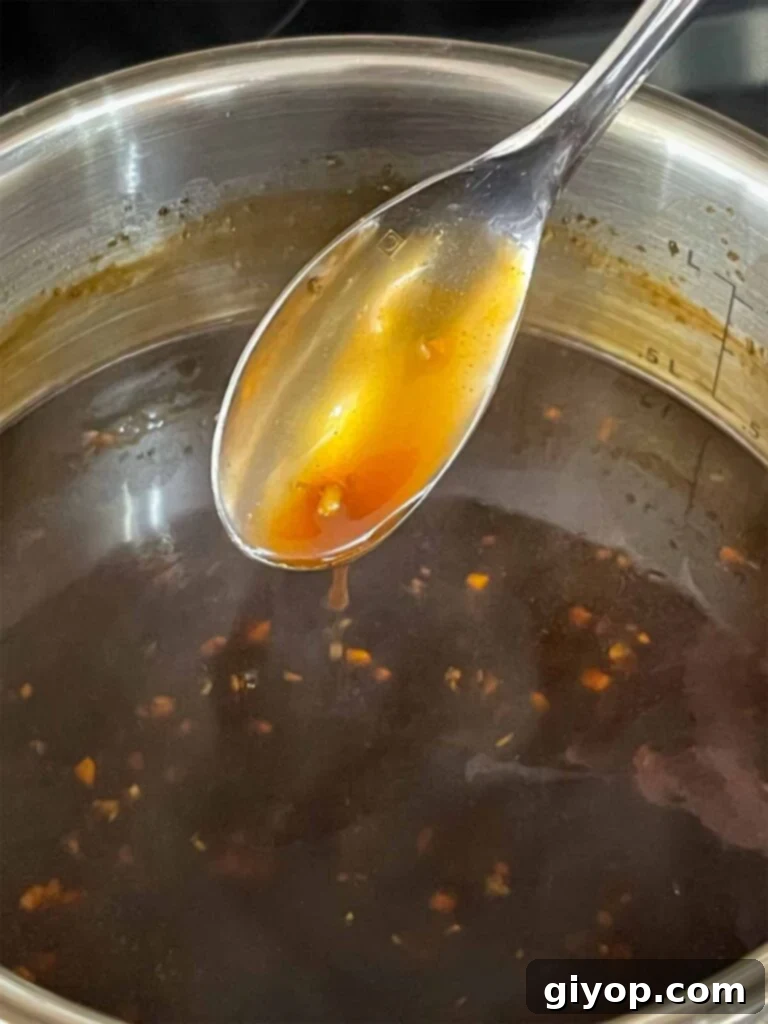 Bourbon sauce, cooked, with a spoon showing off the thickness.