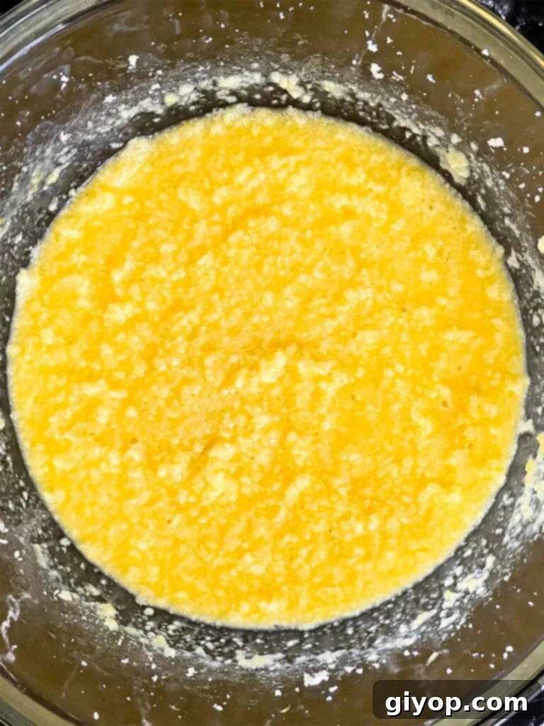 Lemon crumb cake wet ingredients mixed together in a glass mixing bowl.