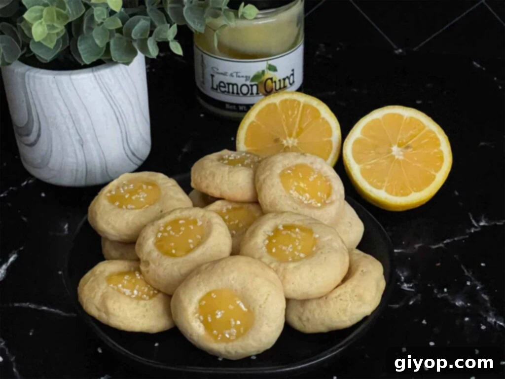 Exquisite Lemon Thumbprint Cookies arranged beautifully on a dark plate, set against a complementary dark background, highlighting their vibrant lemon curd centers.