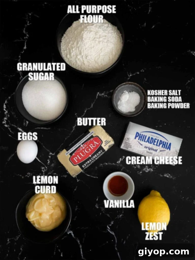 A collection of fresh ingredients for Lemon Thumbprint Cookies, including lemons, butter, sugar, and flour, neatly arranged on a dark surface.